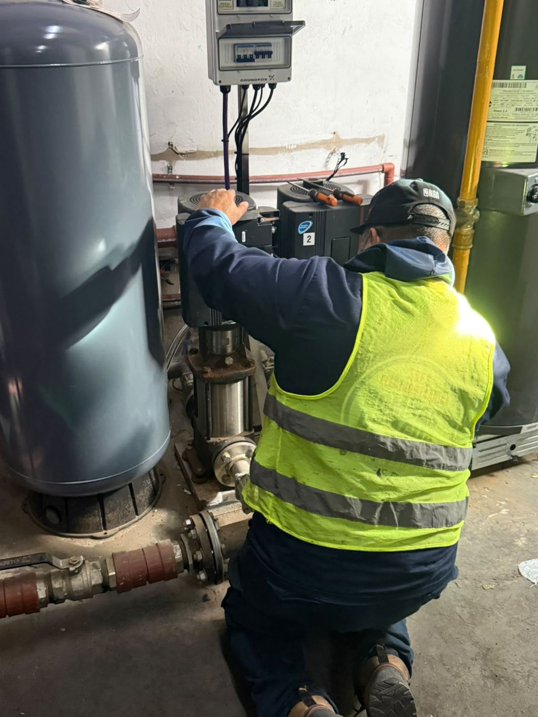 Cristian revisando el tablero de un equipo presurizador de edificio